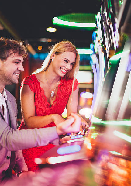 Young couple playing slot machines at the Casino