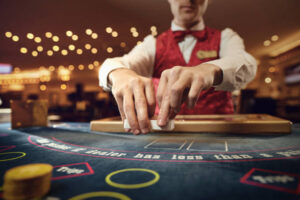 The croupier holds poker cards in his hands at a table in a casino.